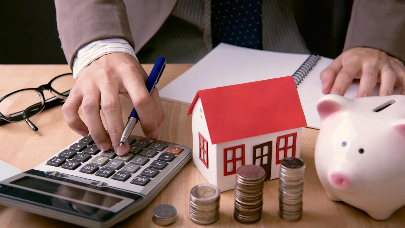 Reduce Home Loan EMI vs Reduce Tenure: Which Prepayment Option Can Help? 9 A calculator and a house icon representing home loan EMI and tenure calculations.